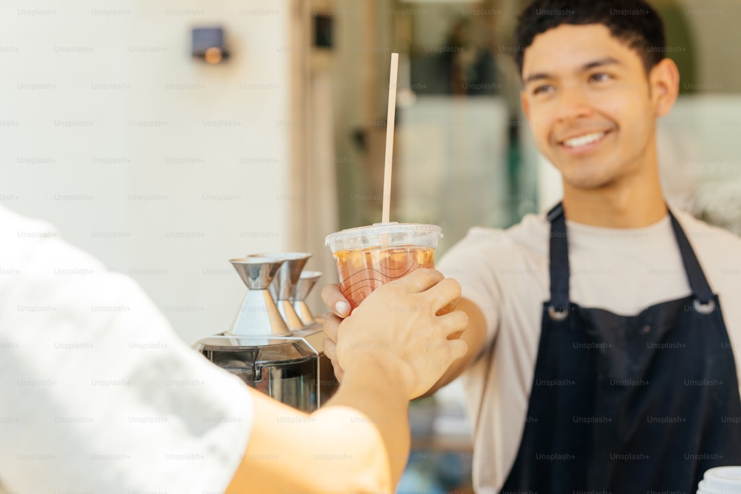 Barista hands a drink to a customer.