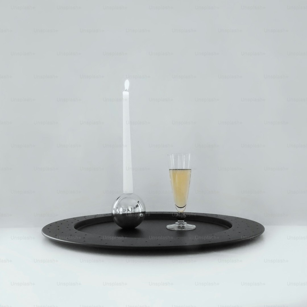 a glass of wine and a candle on a tray
