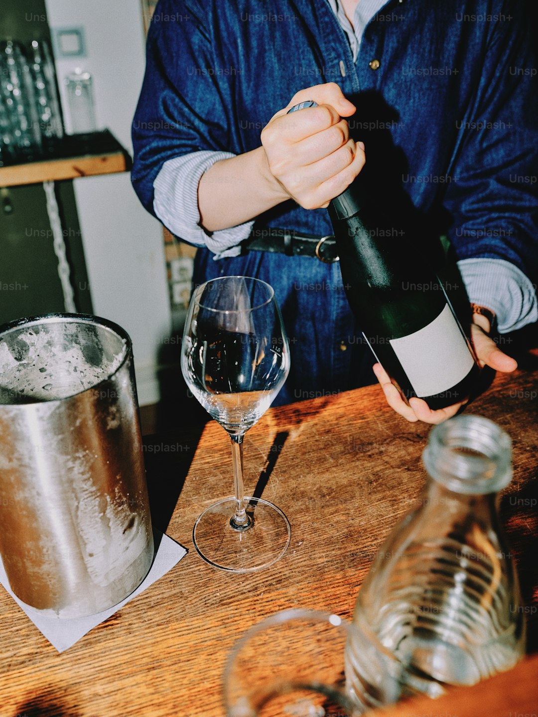 A bartender is opening a bottle of wine.