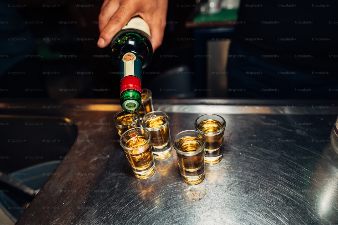 Someone is pouring drinks into shot glasses.