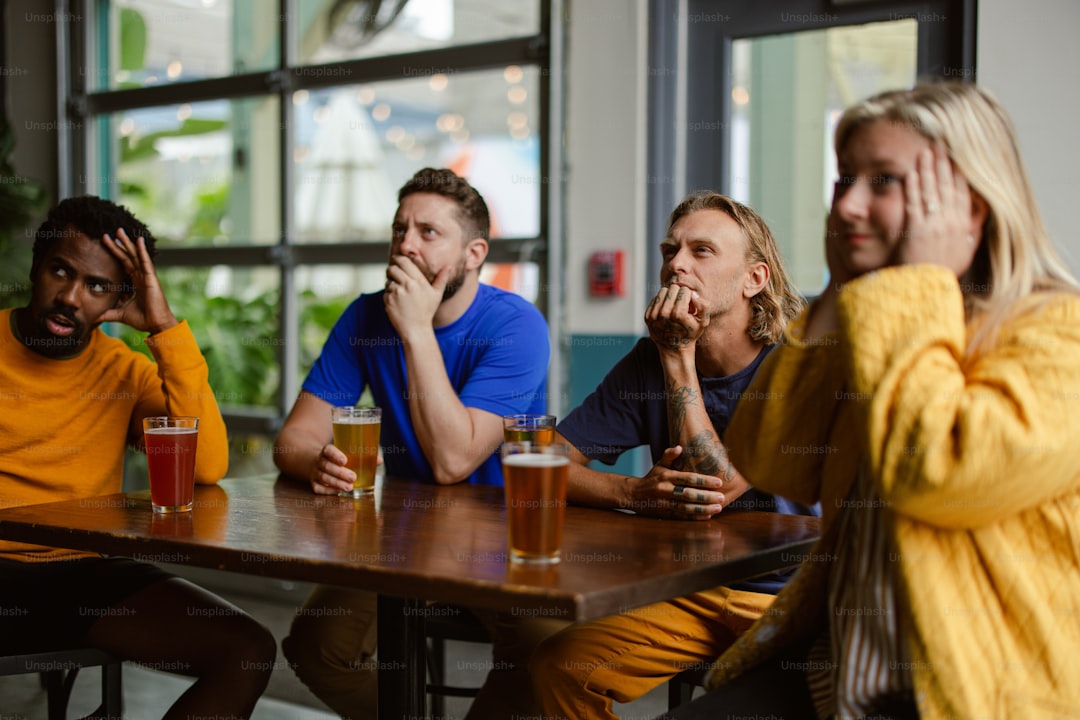a group of people sitting around a wooden table