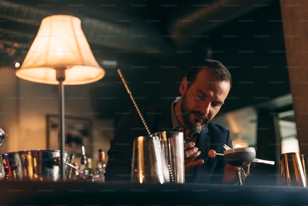 Expert barman is making cocktail at night club.