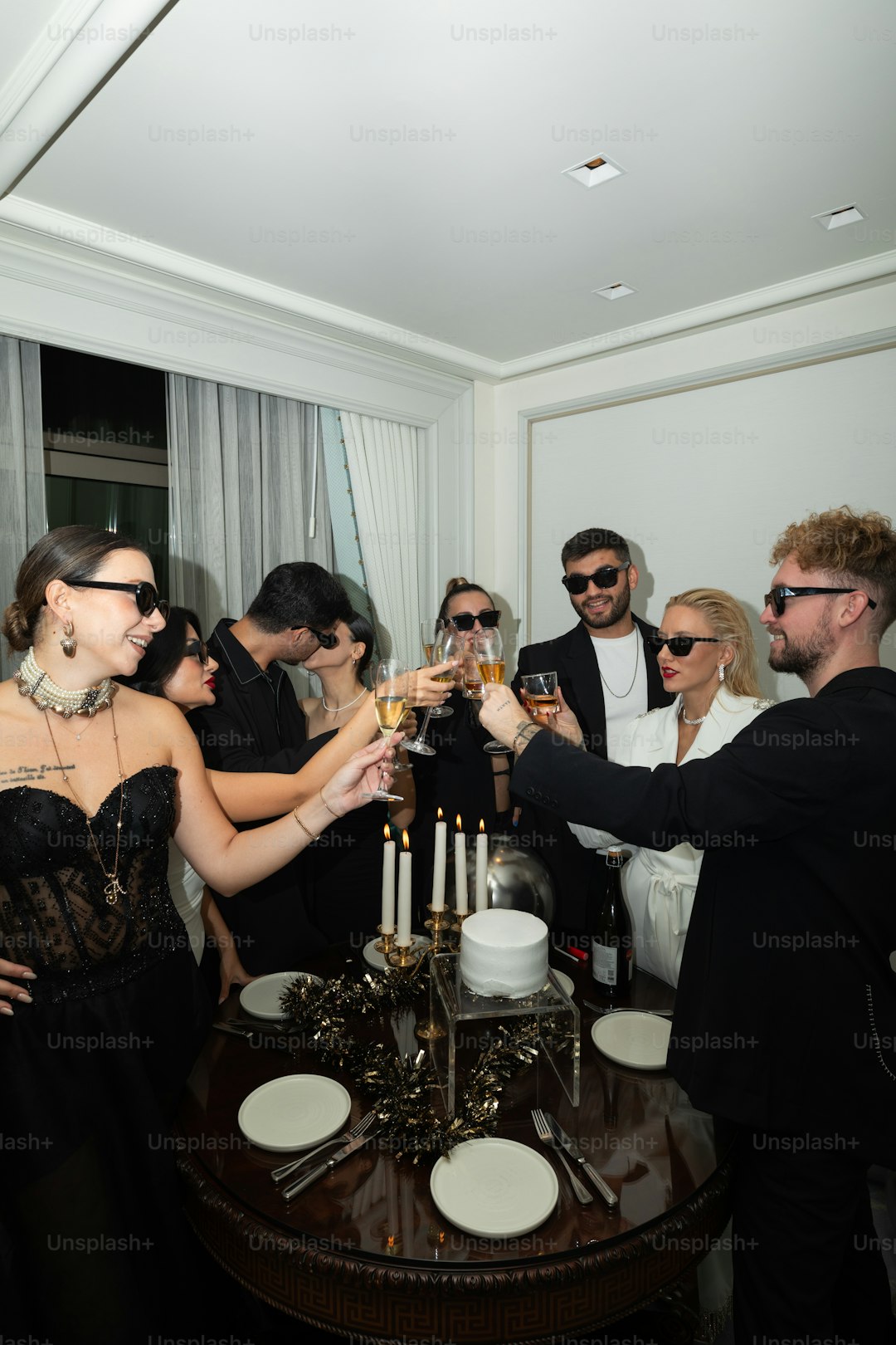 a group of people standing around a table holding wine glasses