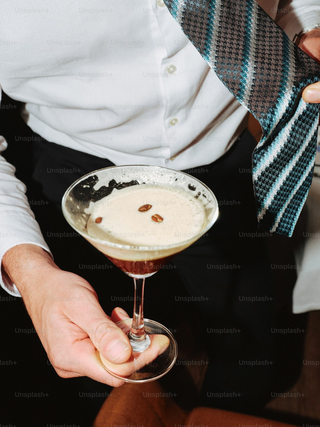 Man holding a martini with coffee beans
