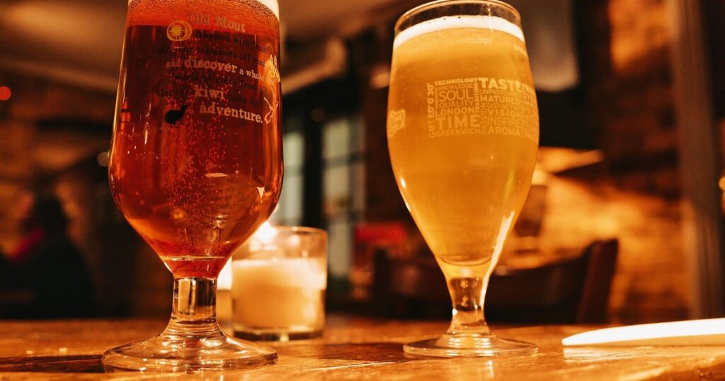 Two light beers on a wooden pub table